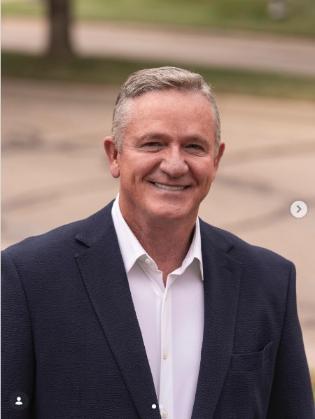 Chock Chapple in a navy blazer, smiling outdoors